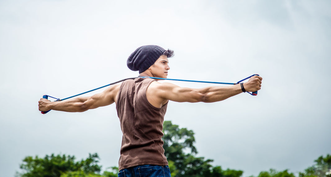 man doing resistance band exercises and stretches outdoors